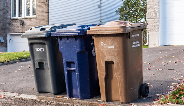 Les 3 bacs de déchets, récupération et compost sont sur le bord de la rue